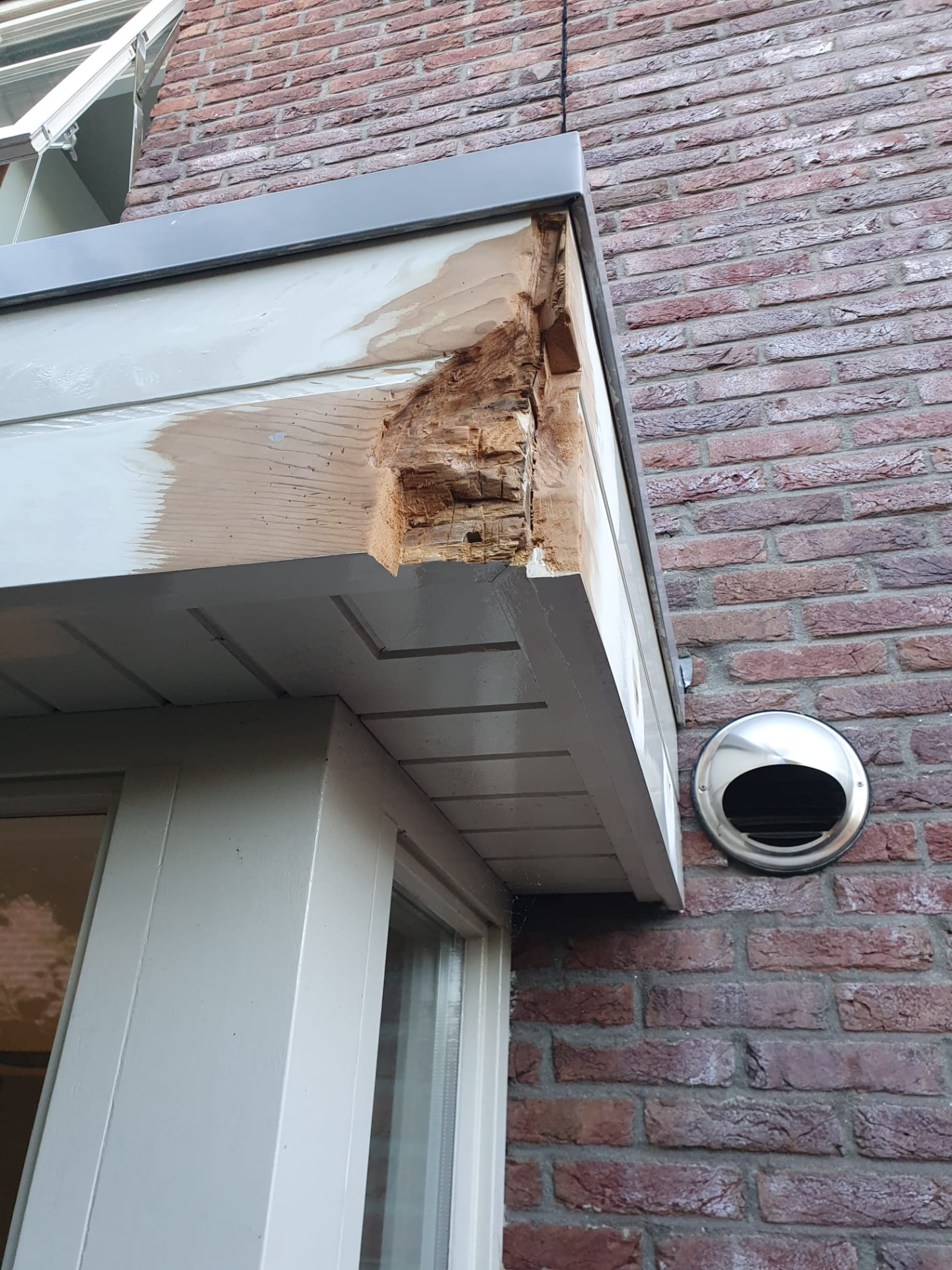 Houtrot in een boeiboord van een woning, uitgehakt voor herstel